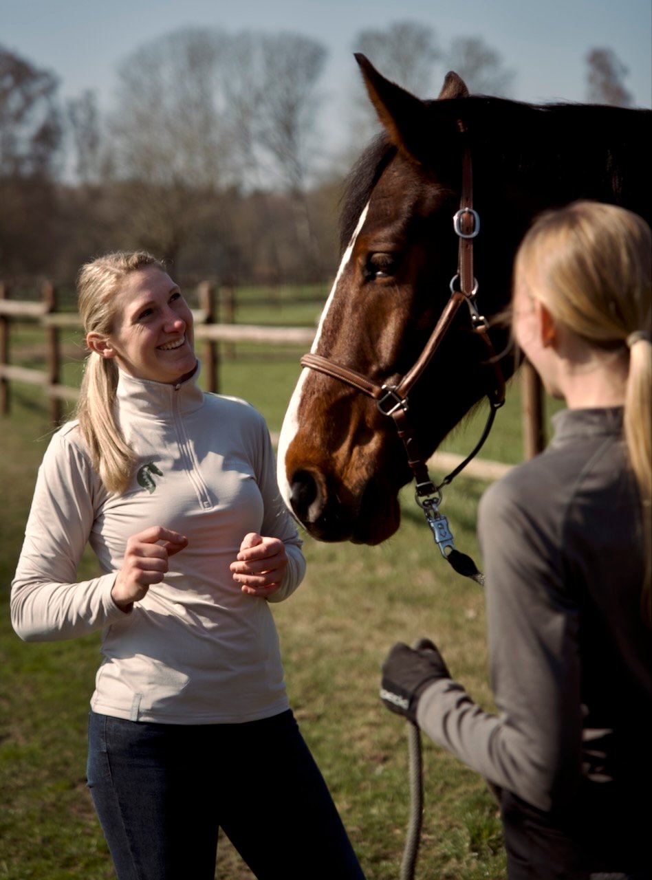 Tierärztin Sara Tadken im Besitzergespräch in der Sonne im Grünen.