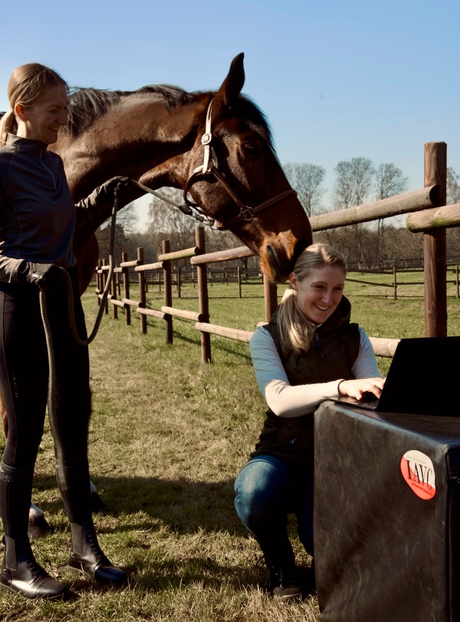 Tierärztin Sara Tadken im Besitzergespräch mit Laptop und Pferd. Es erfolgt die Dokumentation der Anamnese.
