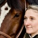 Tierärztin Sara Tadken nebem braunem Pferd mit heller Blässe. Man sieht nur die Köpfe.