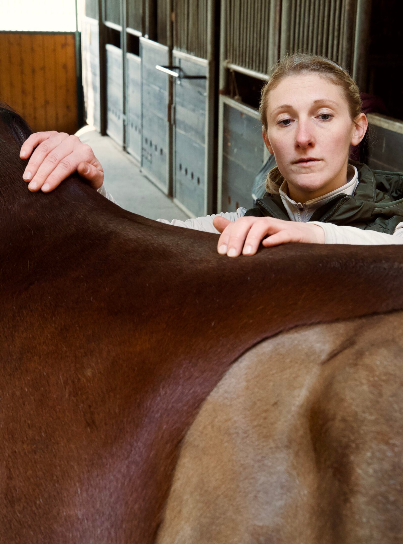 Tierärztin Sara Tadken bei der Palpation der Wirbelsäule eines Pferdes.